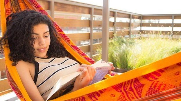 Student reading a book on campus